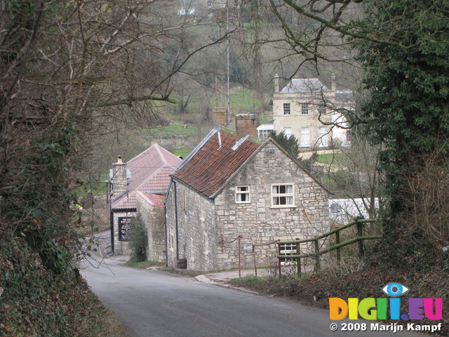 SX01052 Stone houses framed by high hedges and trees